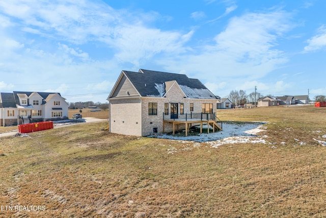 rear view of house featuring a yard and a wooden deck