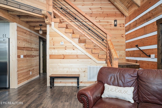 interior space with beamed ceiling, dark hardwood / wood-style floors, wood ceiling, and wooden walls