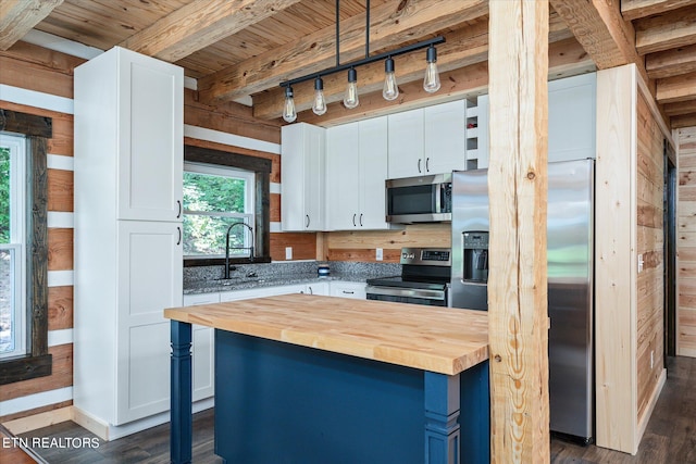 kitchen with dark wood-type flooring, sink, wooden counters, stainless steel appliances, and white cabinets