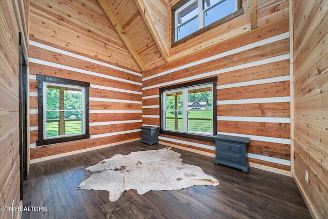 unfurnished room with dark wood-type flooring, a wealth of natural light, high vaulted ceiling, and wood walls