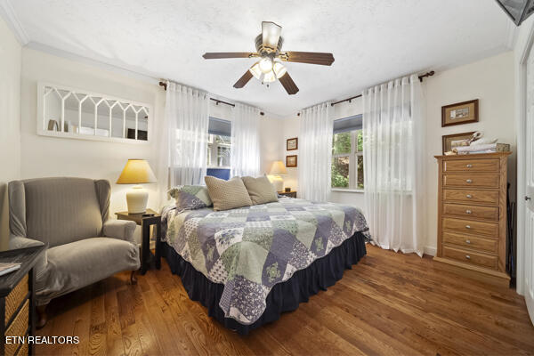 bedroom with ceiling fan, crown molding, and hardwood / wood-style flooring