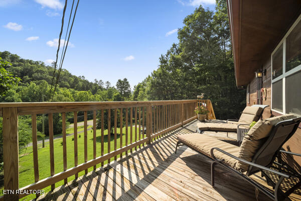 wooden terrace featuring a lawn and outdoor lounge area