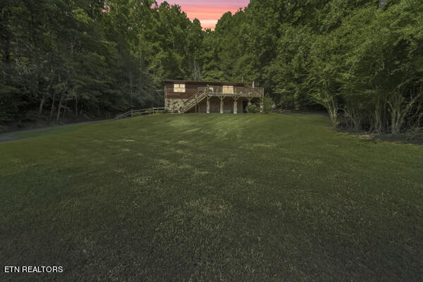 yard at dusk featuring a deck