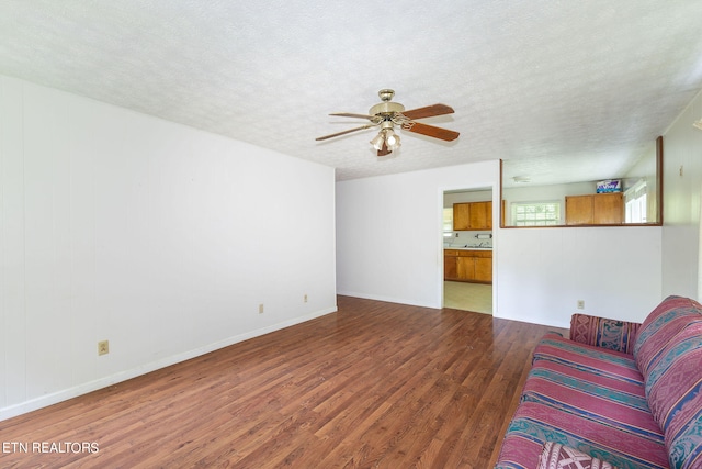 living room with hardwood / wood-style flooring, a textured ceiling, and ceiling fan