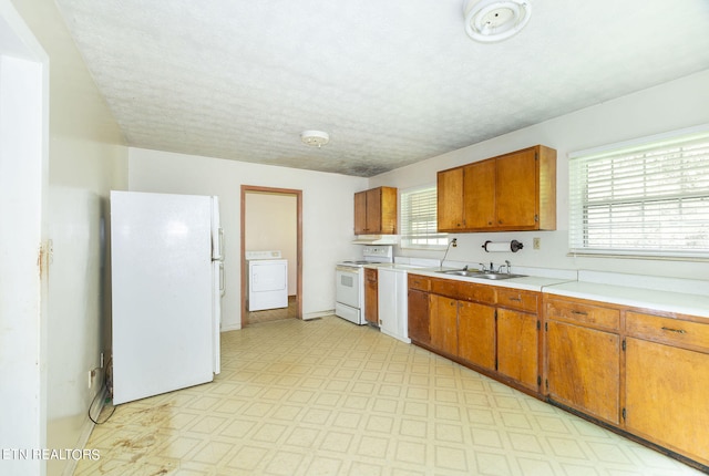 kitchen with washer / clothes dryer, white appliances, a healthy amount of sunlight, and light tile patterned floors