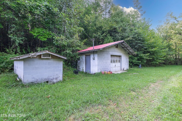 view of yard featuring a garage and an outbuilding