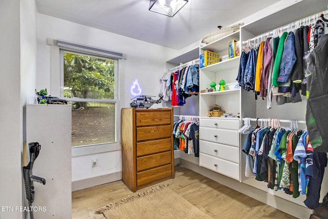 walk in closet with light wood-style floors