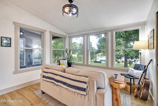 bedroom with vaulted ceiling, light wood-style flooring, and baseboards