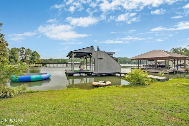 view of dock featuring a water view, a lawn, and a gazebo