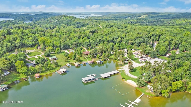 aerial view featuring a forest view and a water view