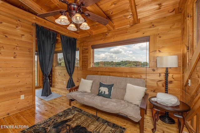 living room with wooden walls, light hardwood / wood-style floors, lofted ceiling with beams, and wood ceiling