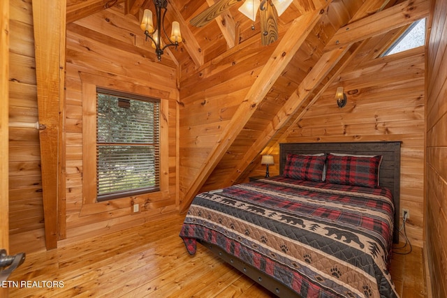 bedroom with lofted ceiling with beams, light wood-type flooring, wooden walls, and wooden ceiling