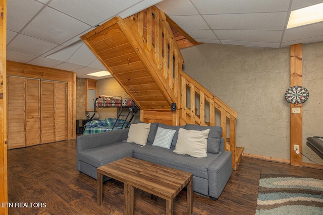 living room featuring a paneled ceiling, wood walls, dark hardwood / wood-style flooring, and vaulted ceiling