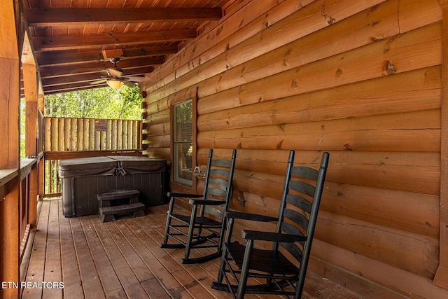 wooden deck with ceiling fan and a hot tub