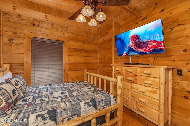 bedroom featuring beam ceiling, wood walls, wood ceiling, ceiling fan, and wood-type flooring