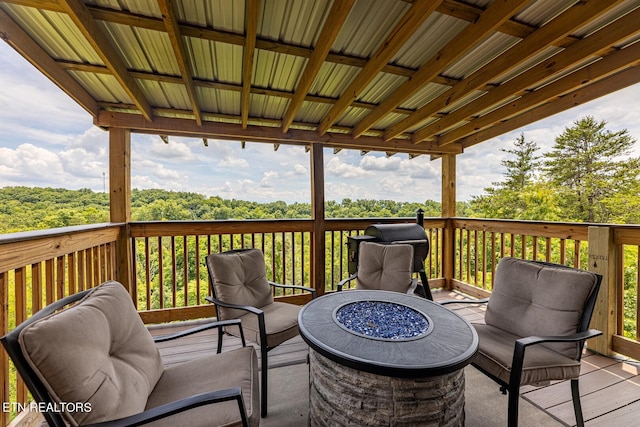 deck featuring an outdoor living space with a fire pit