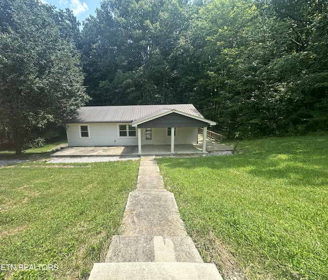 bungalow-style house featuring a patio area, metal roof, and a front yard