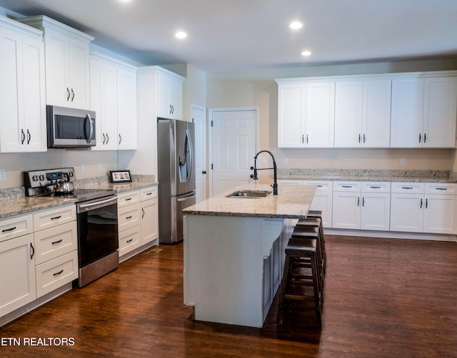 kitchen featuring sink, dark wood-type flooring, stainless steel appliances, and white cabinetry