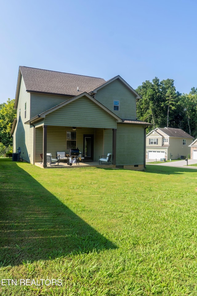 back of property with a patio area and a yard