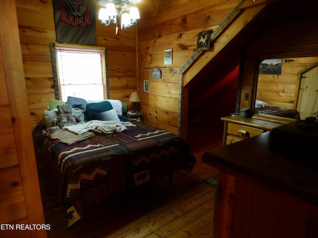 bedroom with wooden walls and wood-type flooring