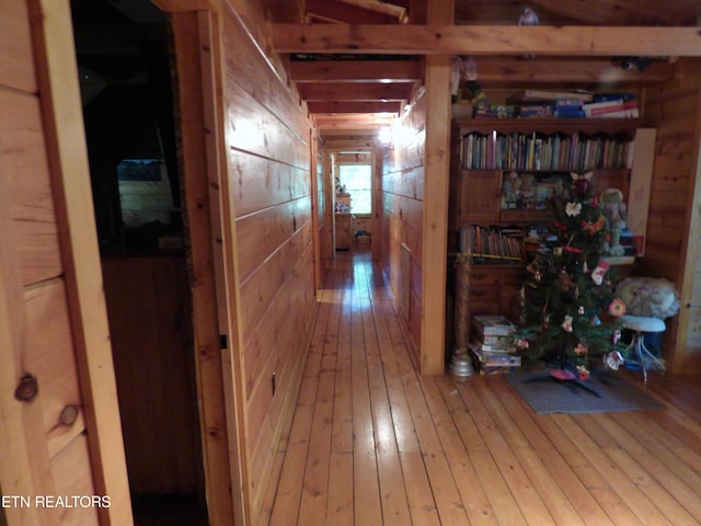 corridor with hardwood / wood-style flooring and wooden walls