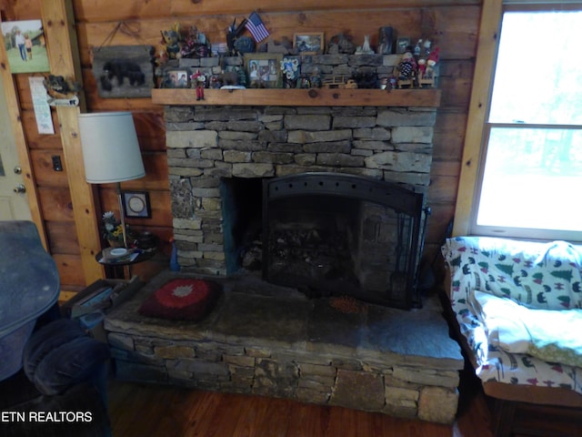 details with hardwood / wood-style flooring and a stone fireplace