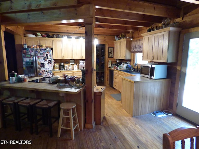 kitchen featuring plenty of natural light, refrigerator with ice dispenser, light hardwood / wood-style flooring, and light brown cabinets