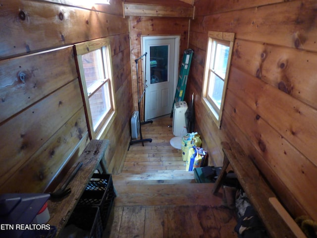 hallway with wood-type flooring and wood walls