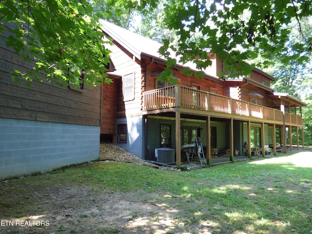 rear view of property with central AC unit, a yard, and a deck