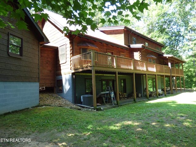 back of property with cooling unit, a yard, and a deck