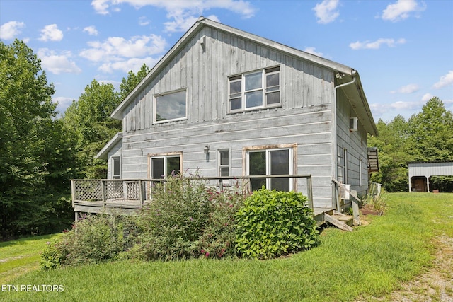 rear view of house with a wooden deck and a yard