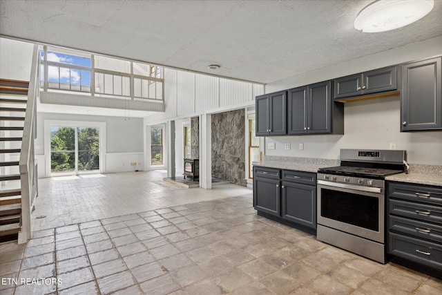 kitchen featuring gray cabinetry, stainless steel gas range, and a textured ceiling