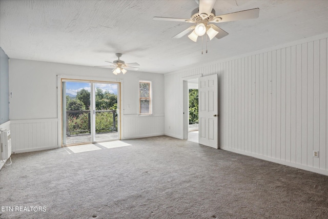 carpeted spare room featuring ceiling fan and a textured ceiling