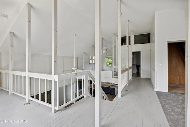 hall with vaulted ceiling and carpet flooring