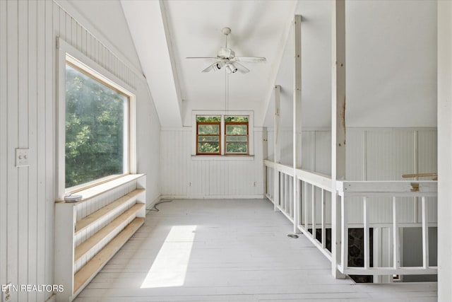 unfurnished sunroom featuring a wealth of natural light, vaulted ceiling, and ceiling fan