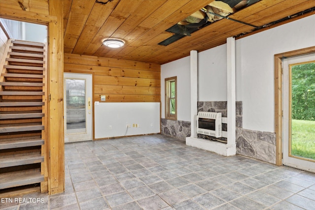 unfurnished living room with a fireplace, heating unit, and wooden ceiling