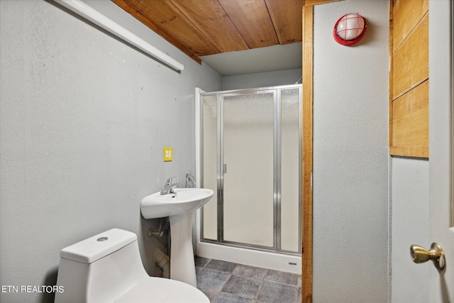 bathroom with toilet, sink, wood ceiling, and a shower with shower door