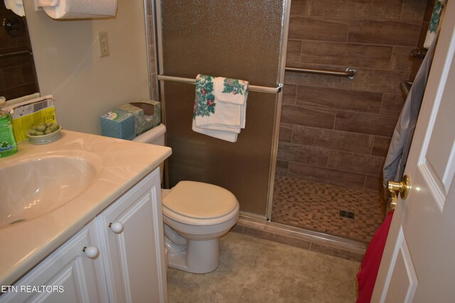 bathroom featuring vanity, an enclosed shower, toilet, and tile patterned floors