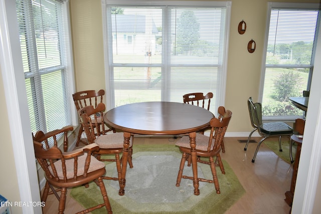 dining space featuring hardwood / wood-style flooring and a healthy amount of sunlight