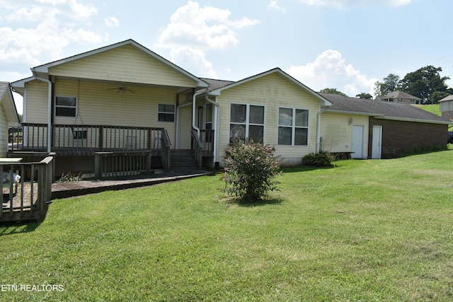 rear view of house featuring ceiling fan, a deck, and a lawn