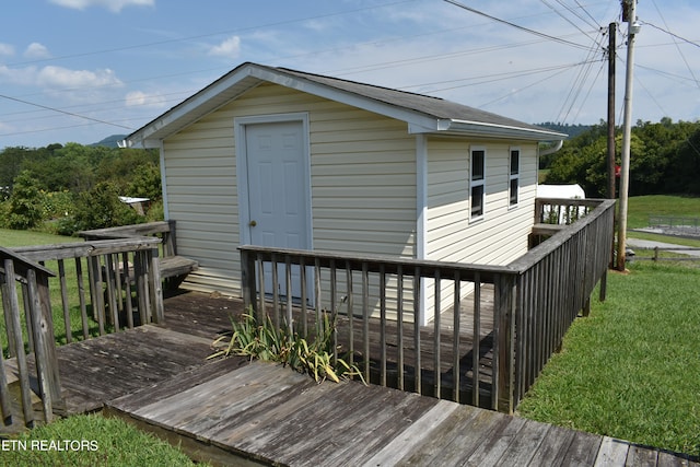 wooden deck featuring a lawn