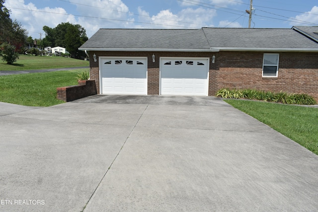 view of side of property featuring a garage and a lawn