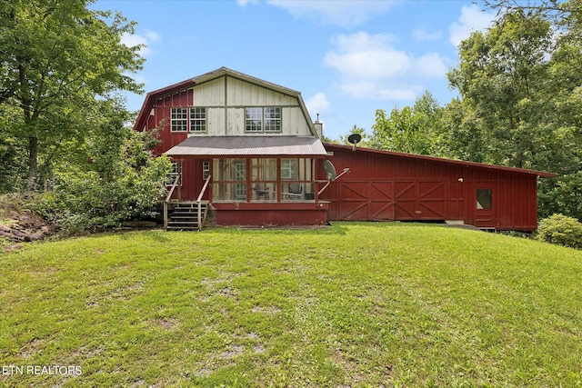 back of property with a yard and a sunroom