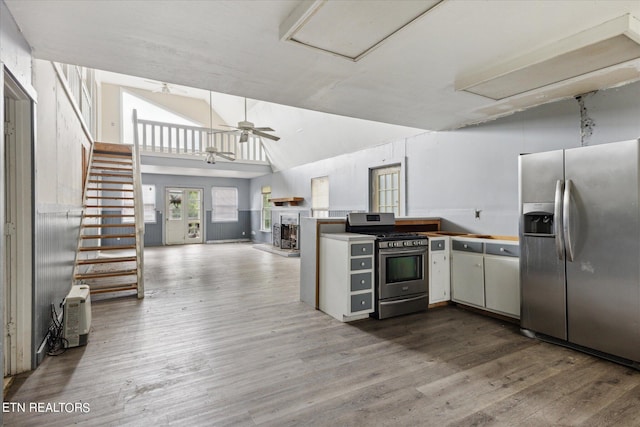 kitchen featuring lofted ceiling, hardwood / wood-style flooring, kitchen peninsula, and appliances with stainless steel finishes