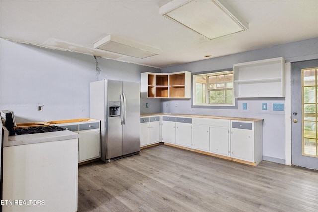 kitchen featuring white cabinetry, stainless steel fridge with ice dispenser, and a wealth of natural light