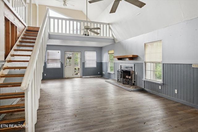 unfurnished living room featuring dark wood-type flooring, ceiling fan, and high vaulted ceiling