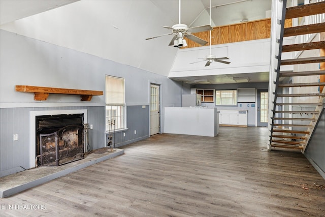 unfurnished living room featuring a fireplace, dark hardwood / wood-style floors, and high vaulted ceiling