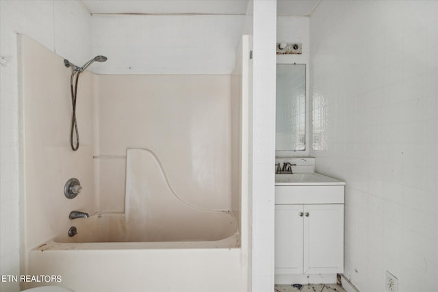 bathroom with tile walls, vanity, and shower / bathtub combination