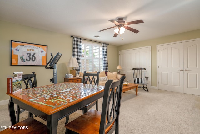 dining room with ceiling fan, visible vents, baseboards, and light colored carpet