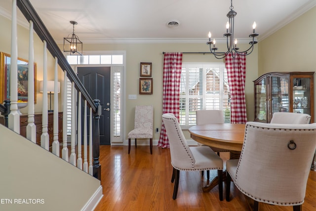 dining area featuring ornamental molding, stairway, visible vents, and a notable chandelier